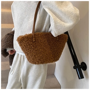 Detail of plush brown shearling tote bag with leather strap and decorative beads