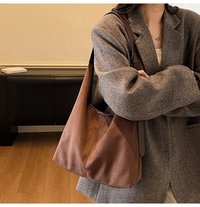 Detail of the adjustable leather strap and matte suede texture on the large brown tote bag