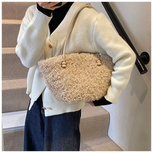 Detail of plush beige shoulder bag with soft faux fur texture and wooden bead handle