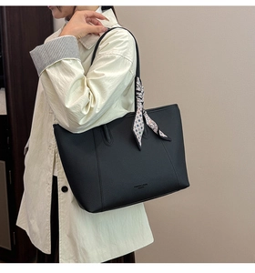 Close-up of black litchi pattern leather tote bag with geometric silk scarf detail