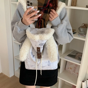 Detail of white canvas backpack featuring plush bunny ears and brown leather buckle