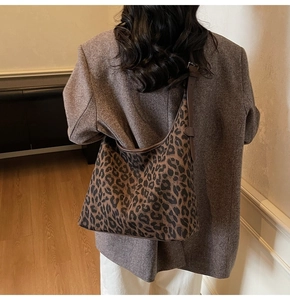Lifestyle shot of large leopard print hobo tote bag worn over a brown blazer
