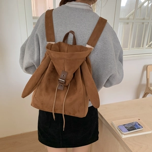 Detailed view of brown faux suede bunny ears backpack worn with a grey casual hoodie