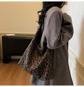 Detail of leopard print hobo bag with fabric texture and brown leather strap accents