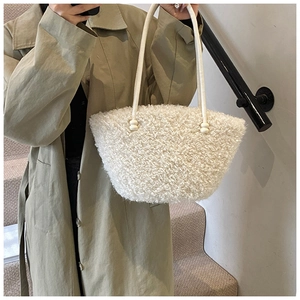 Detail of white plush shoulder bag with lamb wool texture and leather strap on a model