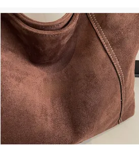 Macro shot of dark brown frosted suede fabric with neat cream topstitching details