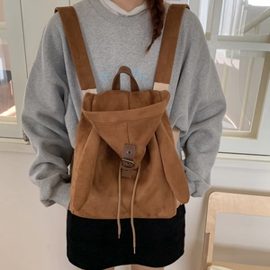 Detail of a brown suede backpack featuring cute rabbit ears and metallic buckle closure