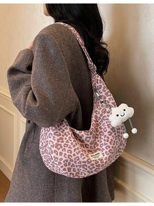 Pink leopard print canvas crescent tote bag with plush cloud charm and wide strap