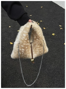 Détail de sac en fausse fourrure motif cerf avec pendentif doré et bandoulière chaîne