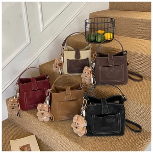 Collection of frosted suede bucket bags in five colors with cute bear plush charms