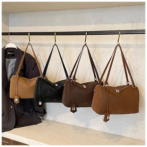Detail of four retro Boston bags in khaki, black, and brown with silver locks