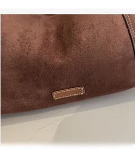 Detail of dark brown suede tote featuring premium texture and white contrast stitching