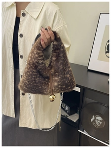 Vue détaillée du sac en peluche d'hiver avec texture animalière et breloque boule dorée