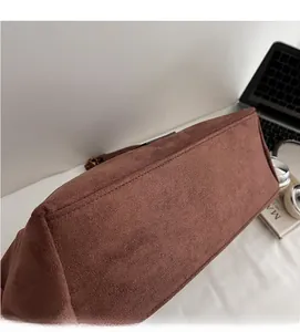 Vue détaillée du sac cabas en daim marron avec texture mate et coutures latérales