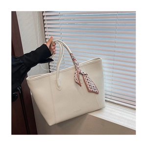 Close-up of white lychee-patterned tote bag with a decorative floral silk scarf handle