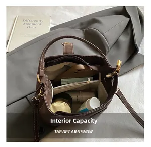 Internal capacity of brown leather bucket bag showing compartments and stitching details