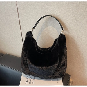 Close-up of the plush black faux fur texture and leather strap on the shoulder bag