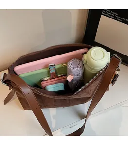 Intérieur spacieux du sac à bandoulière marron mat avec rangement tablette et parapluie