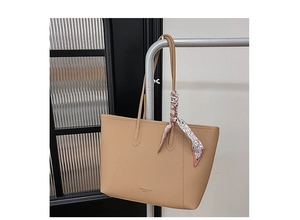 Close-up of light brown lychee grain tote bag with silk scarf and fashion logo