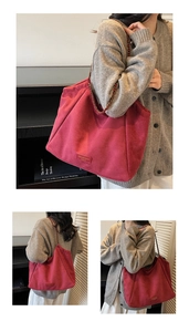 Vue détaillée du cabas en daim magenta avec bandoulière chaîne et logo de la marque