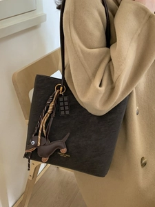 Brown leather tote bag with sausage dog charm and chocolate tag in an autumn commute style