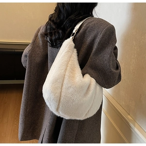Detail of faux fur shoulder bag in creamy white featuring leather strap and metal rings