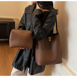 Détail du sac seau vintage en cuir marron avec fermoir doré et petite pochette assortie