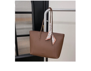 Detailed texture of brown pebble leather tote bag with stylish printed silk scarf decoration