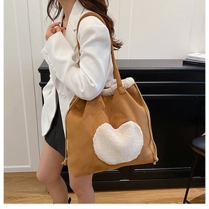 Detail of large brown faux suede tote bag with white plush heart and drawstring