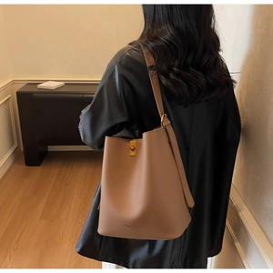 Détail de sac seau en cuir grainé marron avec fermoir métallique doré élégant et chic