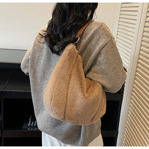 Detail of fluffy brown plush tote bag with faux fur texture and leather strap