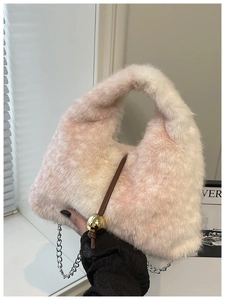 Détail du sac en peluche dégradé rose et blanc avec breloque dorée et chaîne argentée
