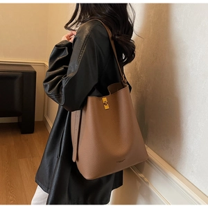 Vue détaillée du sac seau en cuir marron grainé avec fermoir doré et bandoulière longue