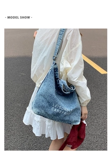 Photo de mannequin d'un sac hobo en jean délavé bleu avec lettrage blanc artistique