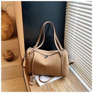 Detail of khaki tote bag showing dual zipper closure and decorative metal padlock