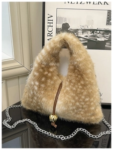 Détail du sac bandoulière en fausse fourrure à motif cerf avec pendentif boule dorée