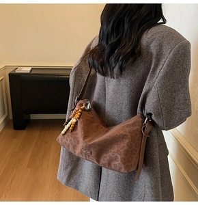 Détail d'un sac bandoulière léopard avec des pampilles colorées en perles fantaisie