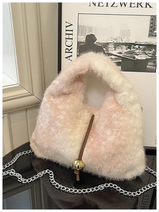 Détail du sac à main en fausse fourrure pelucheuse avec dégradé rose et pendentif doré