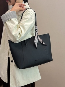 Minimalist black pebble leather tote bag with elegant floral scarf and golden logo