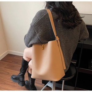 Détail du sac seau en cuir litchi kaki avec fermoir doré et imprimé tendance