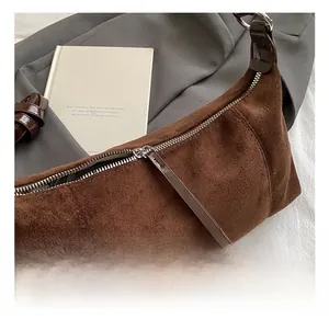 Gros plan du sac en daim marron avec fermeture éclair en métal argenté et tirette longue