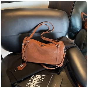 Detailed macro shot of the brown leather Boston bag texture on a vintage chair