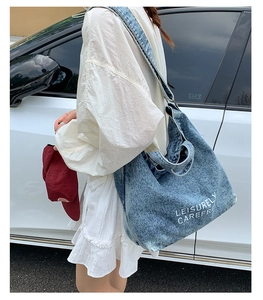 Sac cabas en jean bleu avec texte Leisurely Carefree présenté dans un cadre extérieur