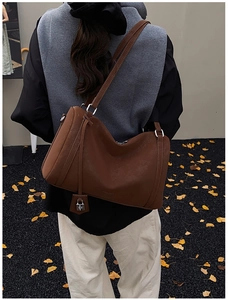 Detailed back view of a large dark brown leather tote bag with silver lock charm