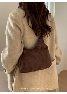 Gros plan du sac hobo en daim marron au style rétro minimaliste sur un mannequin