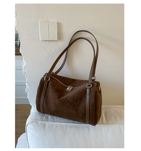 Detailed close-up of dark brown matte suede tote bag featuring silver zipper and leather trim