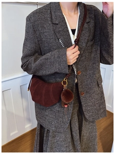 Brown suede croissant bag with fur pompom detail worn with a herringbone blazer