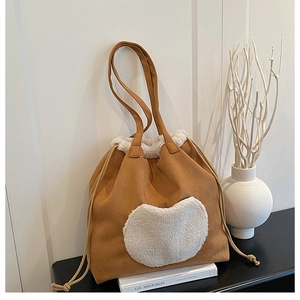 Detail of vintage brown suede tote with white faux fur trim and drawstring feature