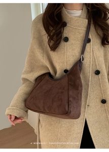 Vue détaillée d'un sac hobo en daim marron foncé avec garniture en cuir et boucle