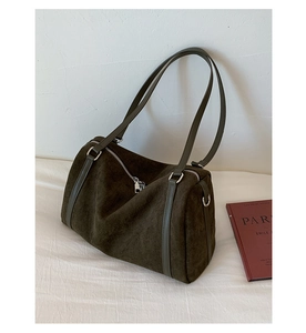 Détail du sac Boston en daim marron foncé avec ferrures argentées et texture douce